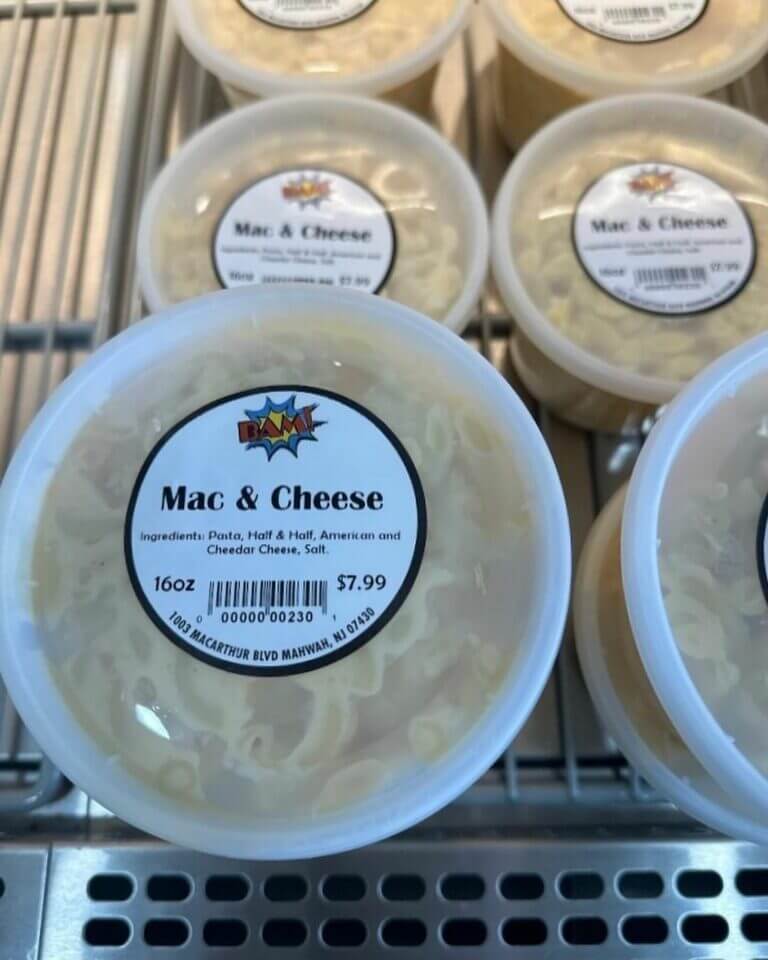 Container of mac and cheese with ingredients and price label, 16oz at $7.99, displayed on a shelf.
